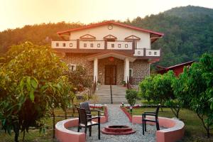 a house with two chairs in front of it at House by the Hills in Dehradun