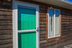 a green door and window on a wooden house at Shangri-La in Folly Beach +40 photos