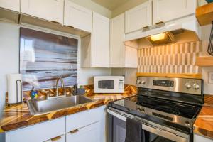 a kitchen with a sink stove and a microwave at Shangri-La in Folly Beach