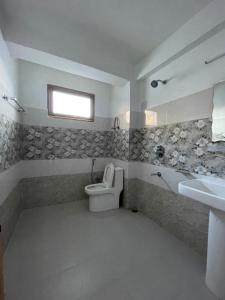 a bathroom with a toilet and a sink at Cloud 9 Chalet in Manāli