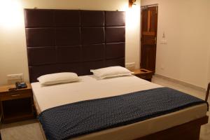 a bedroom with a large bed with a large headboard at Hotel Abhishekh in Port Blair