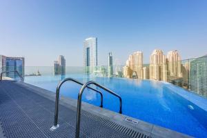 a large swimming pool on top of a building at Stayis - 1 BR Marina suite in Dubai