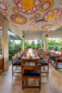 a dining room with tables and chairs and a ceiling with flowers at Skyloft Kandy by Aaradhya in Kandy