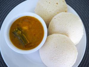 ein weißer Teller mit einer Schüssel Suppe und etwas Essen in der Unterkunft Blue Bells Resort By Maat Hotels in Munnar + 30 Fotos