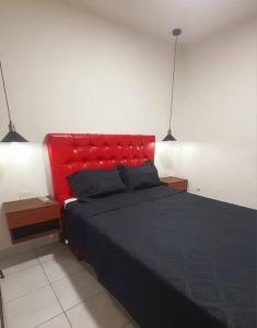 a bed with a red headboard in a bedroom at Apartamento céntrico Frida's todo nuevo in Tarija