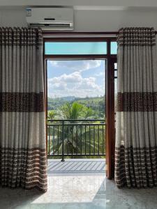 Habitación con una gran puerta de cristal con vistas. en Sara Appartments, en Colombo