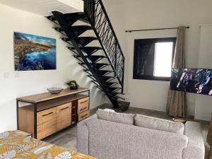 a living room with a staircase and a couch at Les Villas de Bella in Saint-Louis