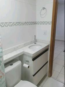 uma casa de banho branca com um lavatório e um WC em Apê 203 - Encantador em condomínio com piscina em Manaus