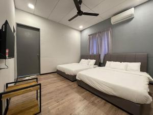 a bedroom with two beds and a ceiling fan at Georgetown 15Px V Kids Pool n KTV n Jacuzzi Spa n Pool Table n Trampoline in Gelugor