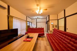 sala de estar con sofá rojo y TV en SHAKUNAGE-BEKKAN - Vacation STAY 85762, en Yufu