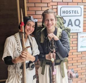 um homem e uma mulher vestidos de uniforme a segurar remos em HOSTEL PAQ tokushima em Tokushima