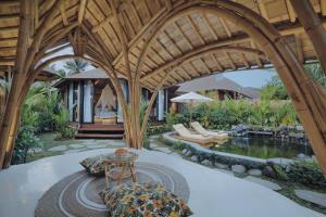 un patio al aire libre con piscina y un pabellón en Wasita Eco Villa Ubud, en Ubud