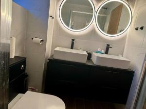 Baño con 2 lavabos y espejo en Entire house with a large lounge en Leverstock Green