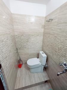 a bathroom with a white toilet in a room at Hotel A R S in Patna