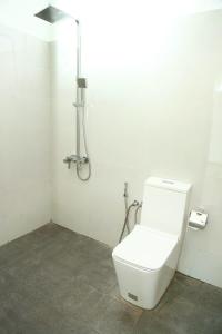 a white bathroom with a toilet and a shower at Eden Rock Luxurious Accommodation in Kandy