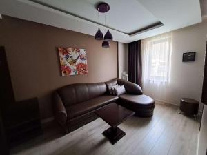 sala de estar con sofá de cuero y silla en Park Hotel Fairy en Chiflik