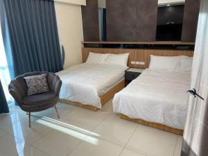 une chambre d'hôtel avec deux lits et une chaise dans l'établissement Mon Homestay, à Taïtung