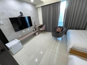 a hotel room with a bed and a flat screen tv at Mon Homestay in Taitung City