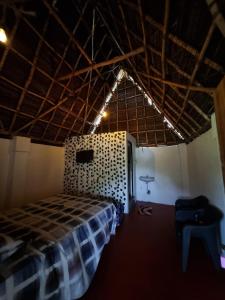 een slaapkamer met een geruit bed in een kamer bij Bhuthaa cottage stay in Auroville