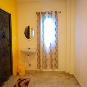 een badkamer met een wastafel en een spiegel bij Bhuthaa cottage stay in Auroville