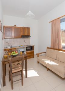 a kitchen and living room with a table and a couch at Esperis in Livadi Astypalaias