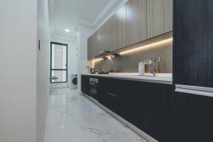 eine Küche mit schwarzen Schränken und einem Waschbecken in der Unterkunft Sky88 High-rise Cozy Stay 2BR nr CIQ/KSL/Midvalley by Our Stay in Johor Bahru