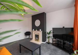 uma sala de estar com televisão e lareira em 4 Bedroom Apartment with non-smoking room - Big special offer for long stays em North Hykeham