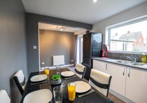 comedor con mesa y sillas y cocina en 4 Bedroom Apartment with non-smoking room, Free WiFi & Parking - Big monthly price reduction en North Hykeham