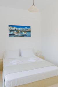 Livadi AstypalaiasにあるEsperisの壁画のある部屋の白いベッド1台