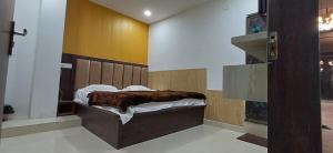 a bedroom with a bed with a wooden headboard at Hotel krishna cottage in Gorakhpur