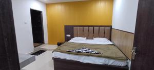 a bedroom with a large bed with a wooden headboard at Hotel krishna cottage in Gorakhpur