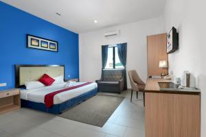 um quarto de hotel com uma cama com uma parede azul em Royal Agate Beach Resort em Pantai Cenang