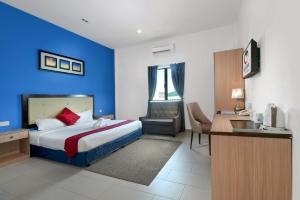 a hotel room with a bed with a blue wall at Royal Agate Beach Resort in Pantai Cenang