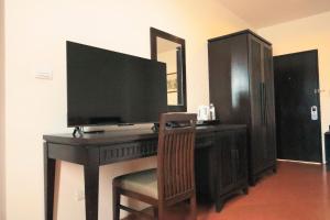 a desk with a television on top of it at Harmony Patong Hotel in Patong Beach