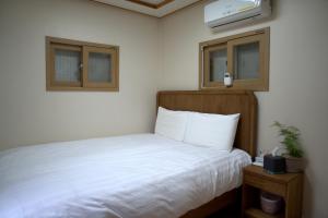 a bedroom with a white bed and a tv at private house JNP stay in Seoul