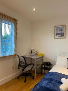 ein Schlafzimmer mit einem Schreibtisch, einem Bett, einem Schreibtisch und einem Stuhl in der Unterkunft Private Rooms near Euston Station, Central London (123) in London