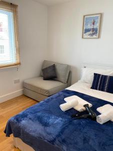 ein Schlafzimmer mit einem Bett mit einer blauen Decke und einer Couch in der Unterkunft Private Rooms near Euston Station, Central London (123) in London