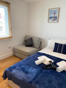 a bedroom with a bed with a blue blanket and a couch at Private Rooms near Euston Station, Central London (123) in London