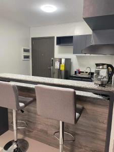 a kitchen with a counter and two bar chairs at Condo Bacolod City in Bacolod