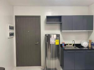 a kitchen with a stainless steel refrigerator and cabinets at Condo Bacolod City in Bacolod