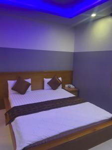 a bedroom with a large bed with a blue ceiling at HOTEL10H in Ho Chi Minh City