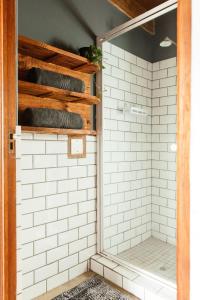 y baño con azulejos blancos de metro y ducha. en Stone cottage in Haarties, en Kalkheuvel