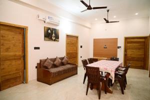 sala de estar con mesa y sofá en Surendra Villa, en Ayodhya