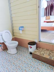 a bathroom with a toilet and a bedroom at Phi Phi Private Beach Resort in Phi Phi Islands