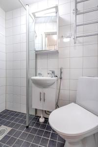 een witte badkamer met een toilet en een wastafel bij Valoisa & Mukava koti vallilassa in Helsinki