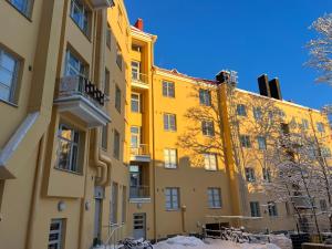 un edificio amarillo con bicicletas estacionadas frente a él en Valoisa & Mukava koti vallilassa, en Helsinki