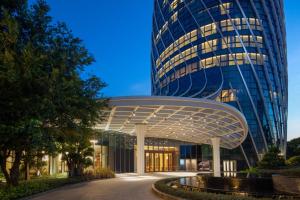 a large blue building with a large building at Hilton Hainan Ocean Flower Island in Danzhou