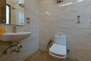 a bathroom with a white toilet and a sink at Hotel King Plaza in New Delhi
