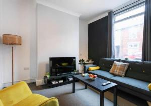 sala de estar con sofá azul y TV en 3 Bedroom Apartment - Big special offer for long stays, en Lincolnshire