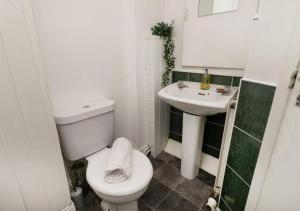 y baño con aseo blanco y lavamanos. en 3 Bedroom Apartment - Big special offer for long stays, en Lincolnshire